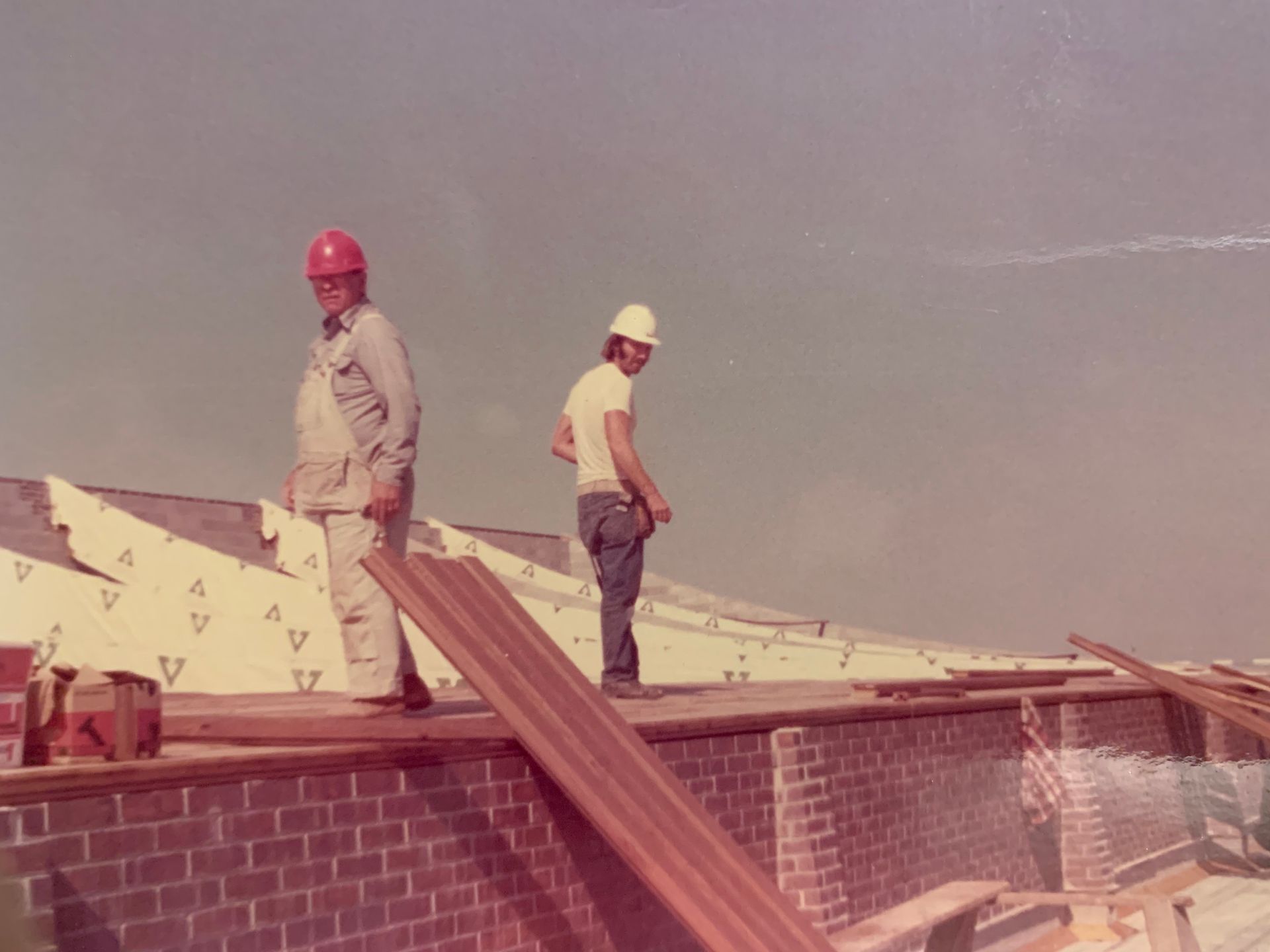 Two construction workers on a roof,