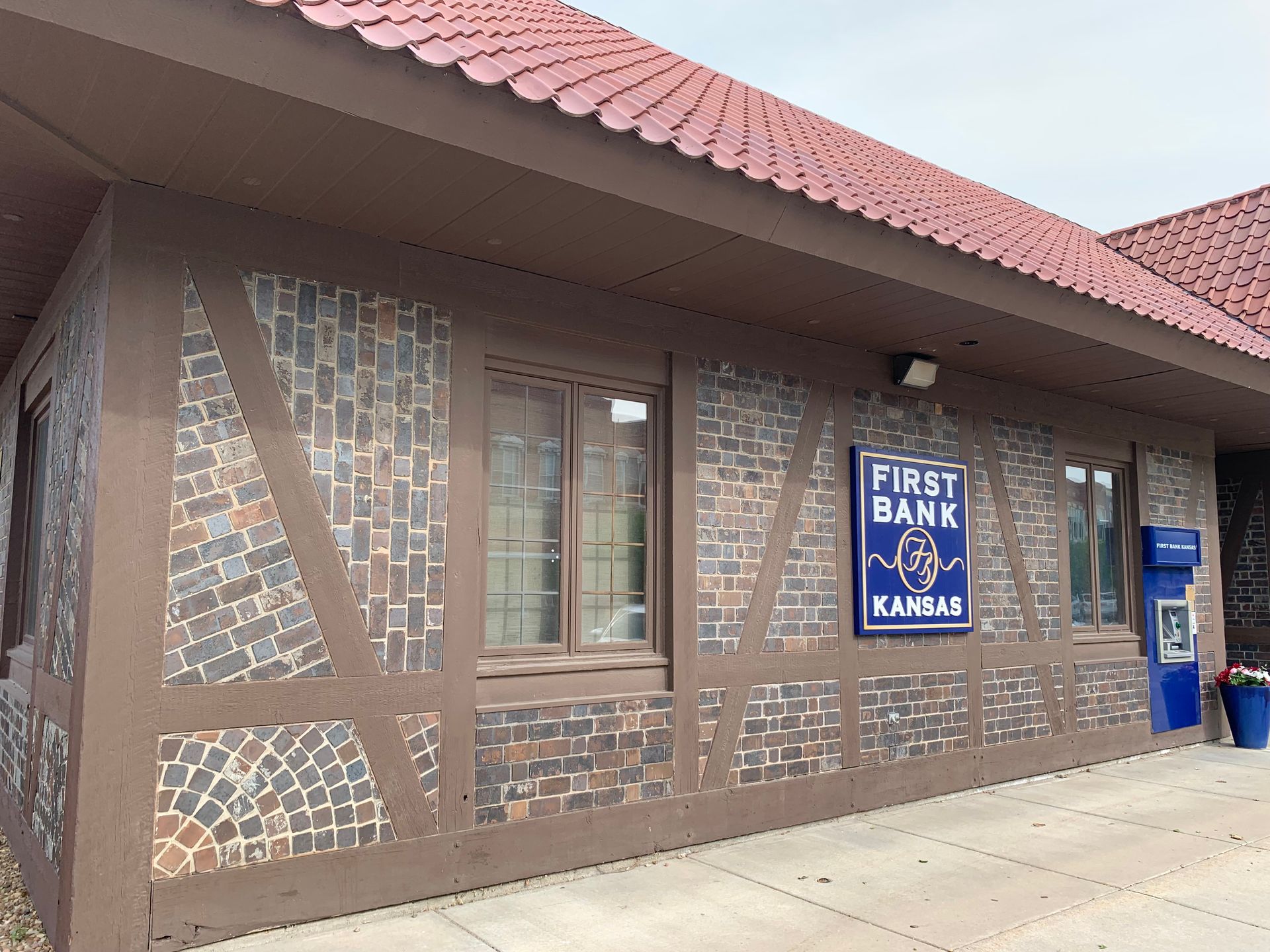 First Bank of Kansas building with brown trim, brick facade, and blue sign.