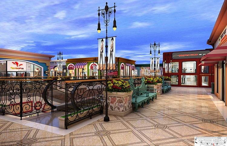 Outdoor shopping mall walkway with benches, shops, and decorative street lamps.