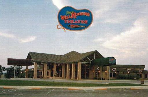The Will Rogers Theatre, a large tan building with a blue sign against a blue sky.