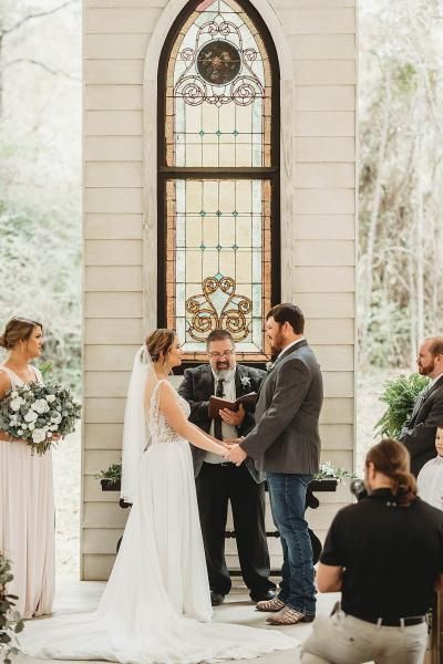 Wedding ceremony with bride and groom exchanging vows before an officiant in a bright chapel