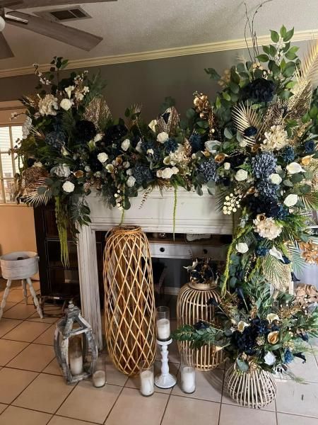 Large floral garland with white and blue flowers draped over a fireplace mantel in a living room.