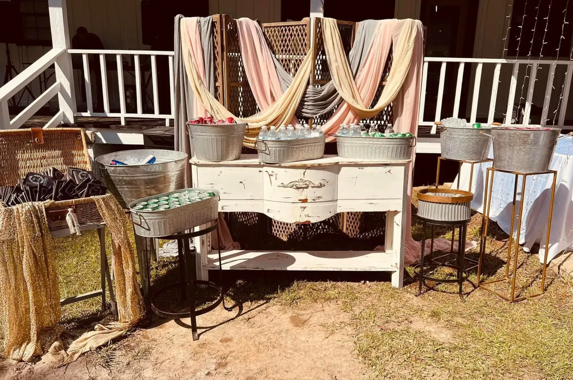 Decorated white dresser with patterned cloths displayed on an outdoor deck with chairs and railing