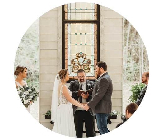 Wedding couple exchanging vows at an altar in a bright church with stained glass window
