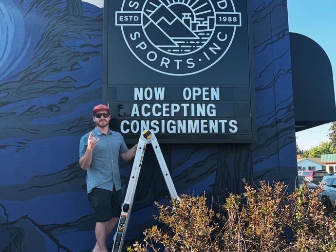 Two people standing in front of a second wind sports store