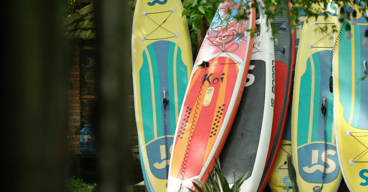 A row of surfboards are stacked on top of each other. A row of surfboards are stacked on top of each other.