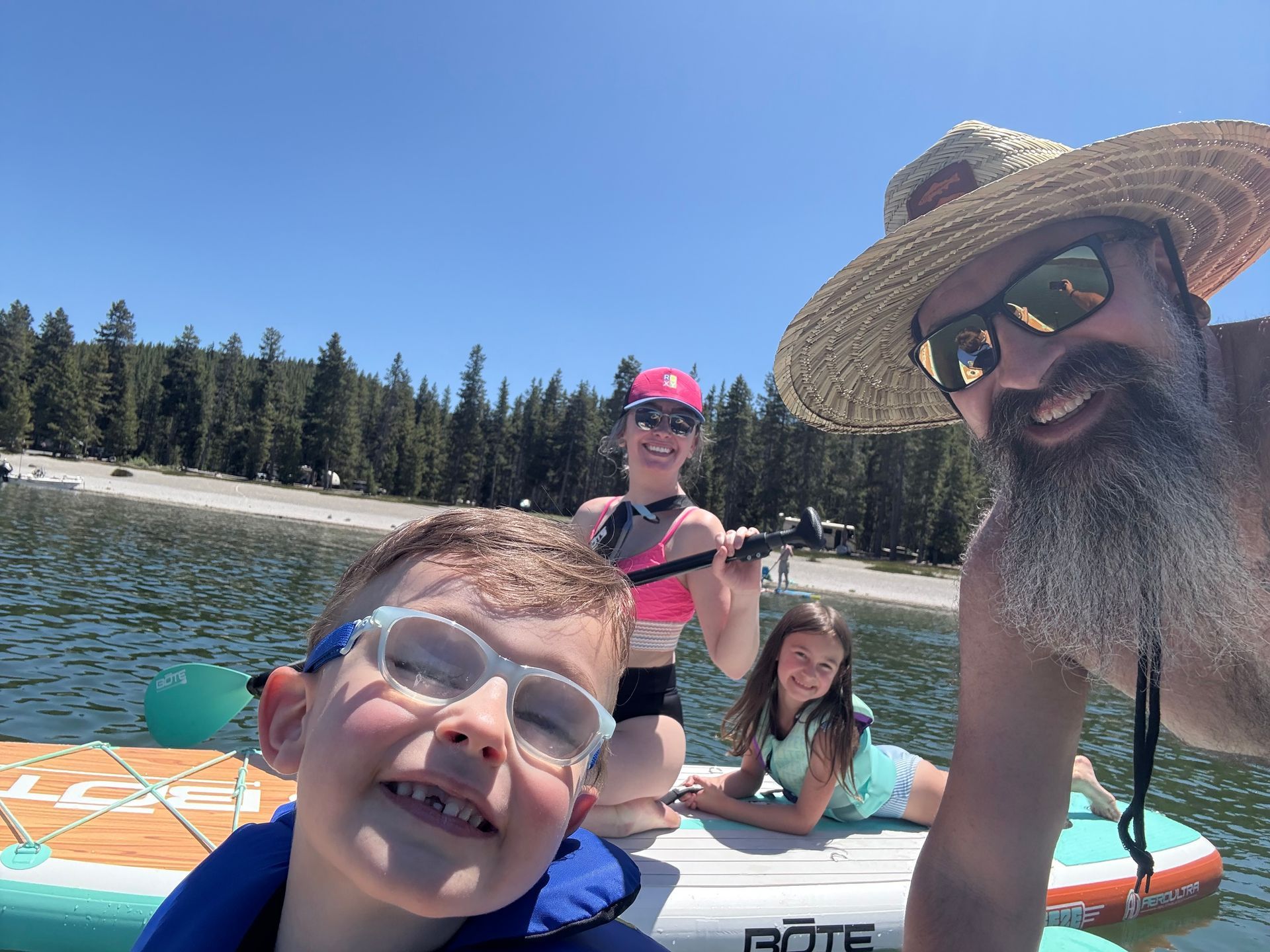 A man and two children are sitting on a raft in the water.