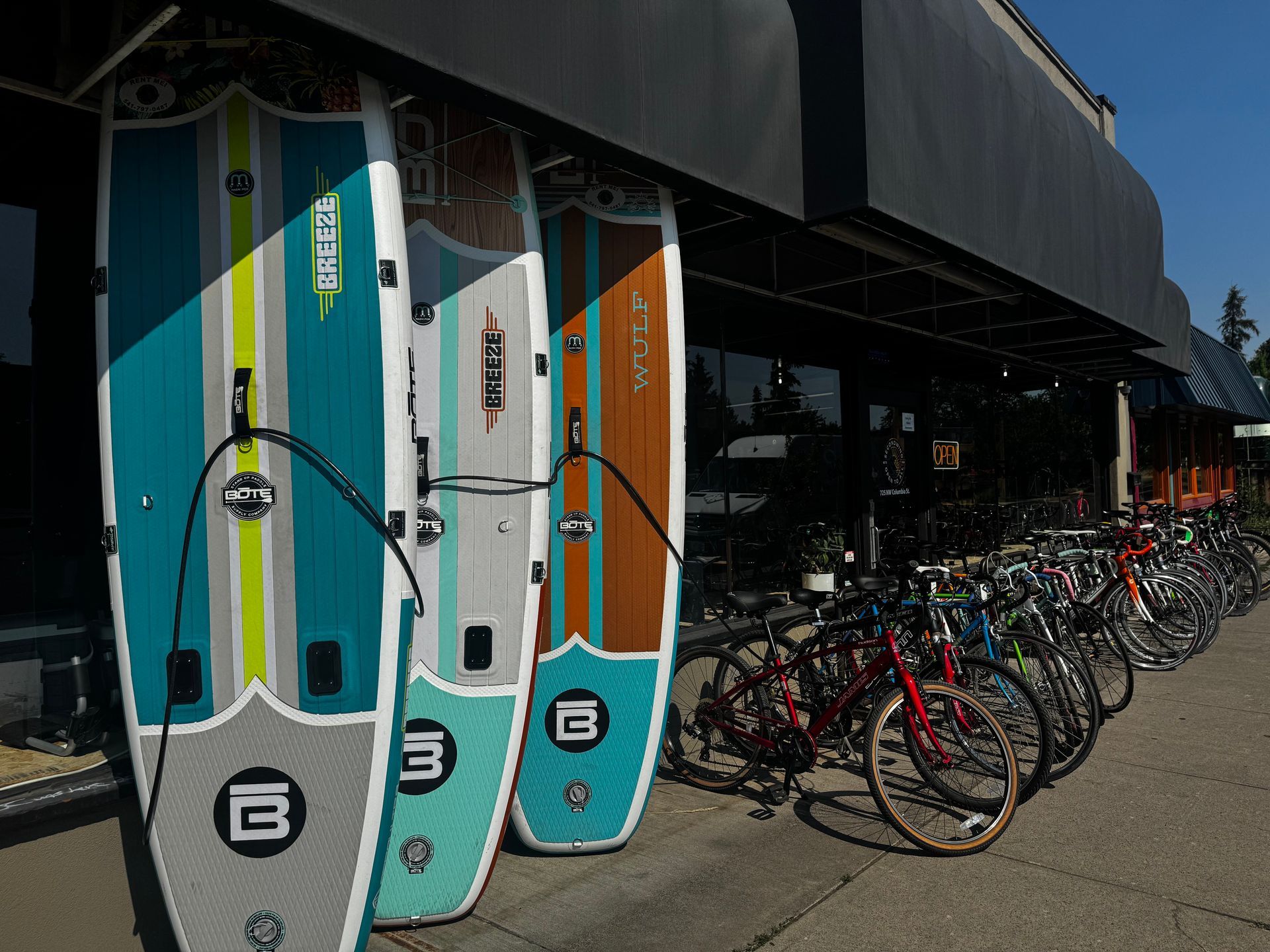 A row of bikes are parked in front of a store.