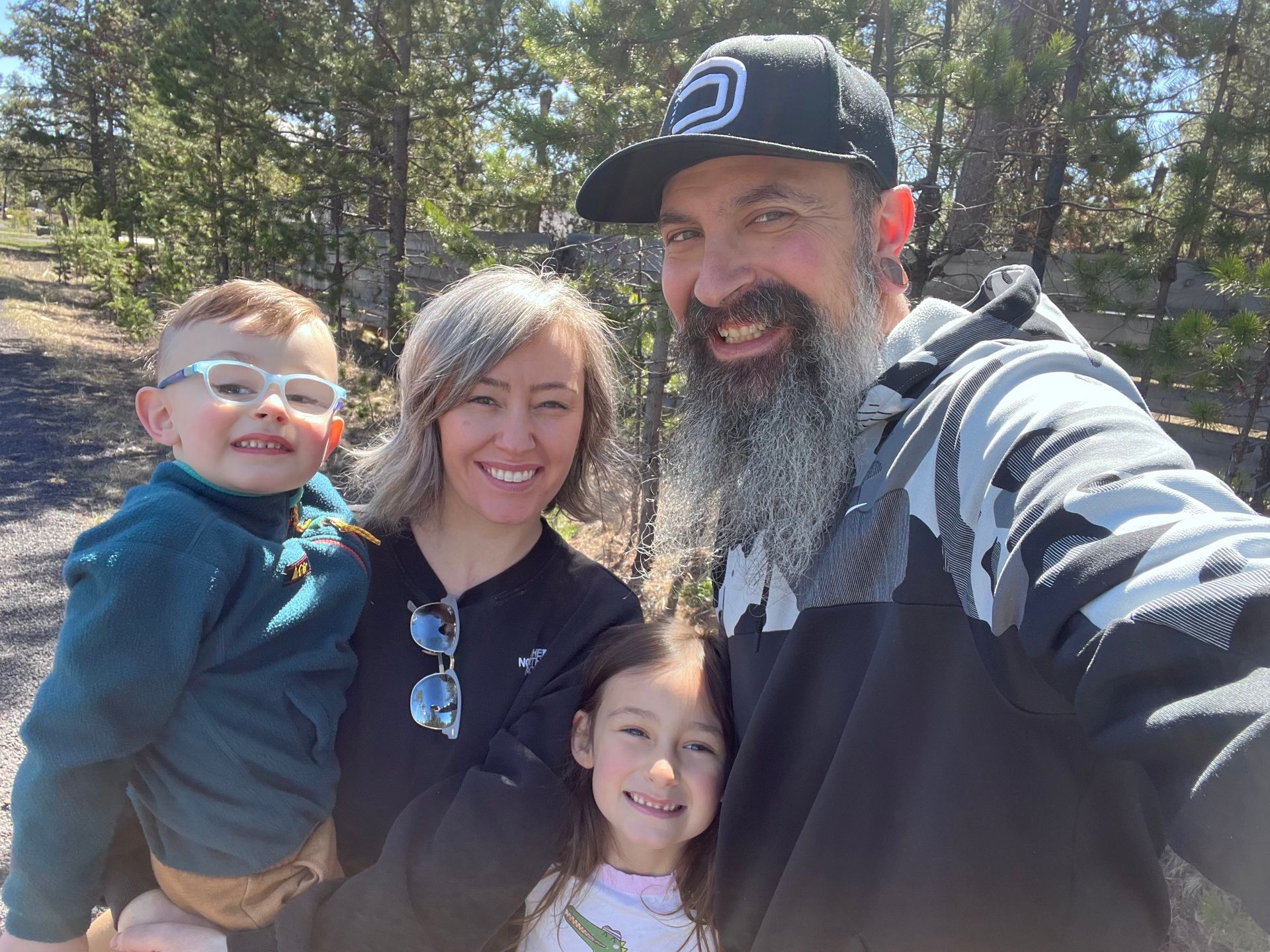 A man with a beard is taking a selfie with his family.
