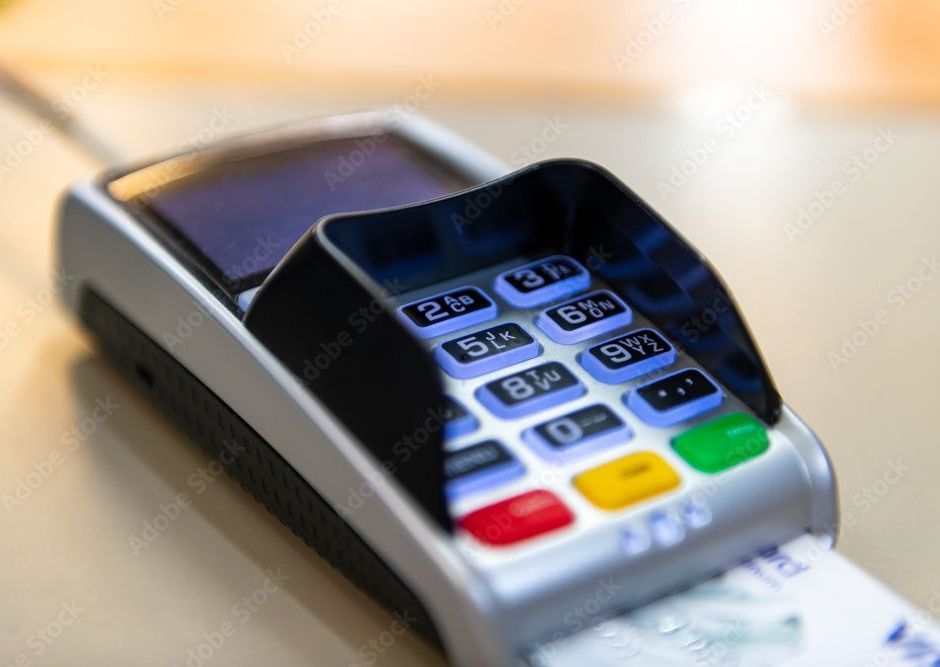 Credit card reader with a card inserted, showing keypad with colorful buttons.
