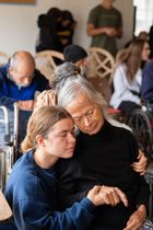 A young girl is hugging an older woman in a nursing home.