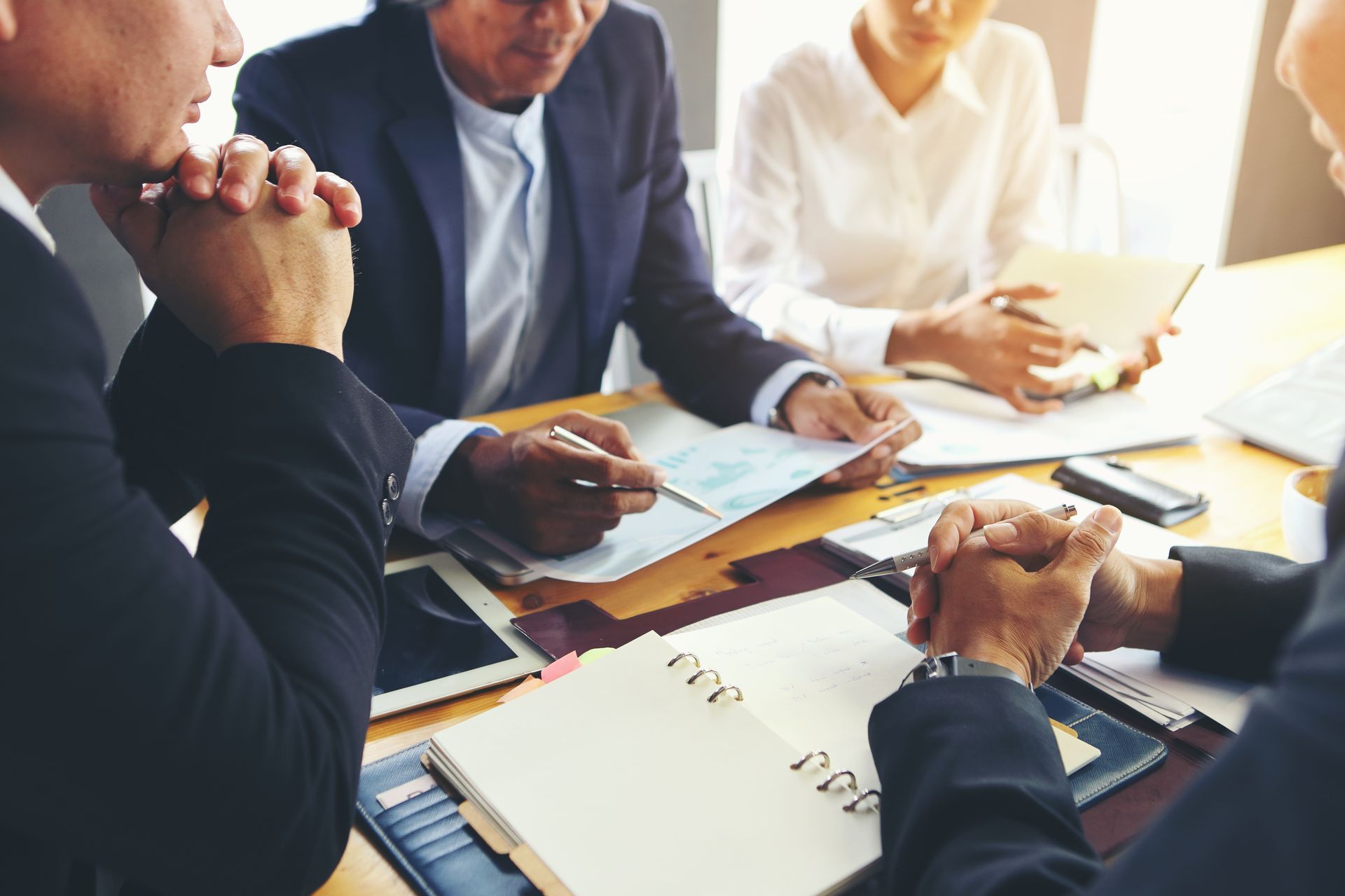 Business meeting with people discussing documents around a conference table