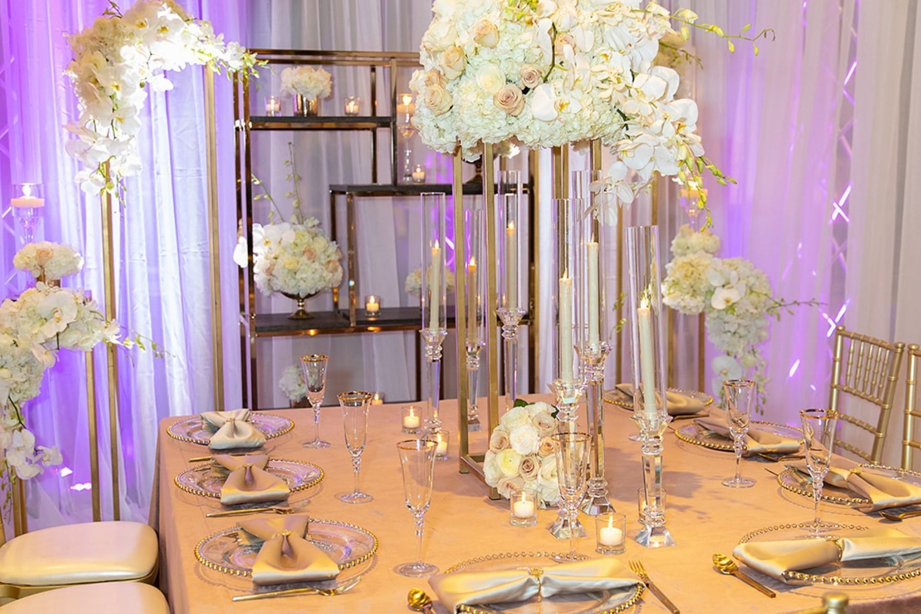 A long table with plates , candles , and flowers on it.