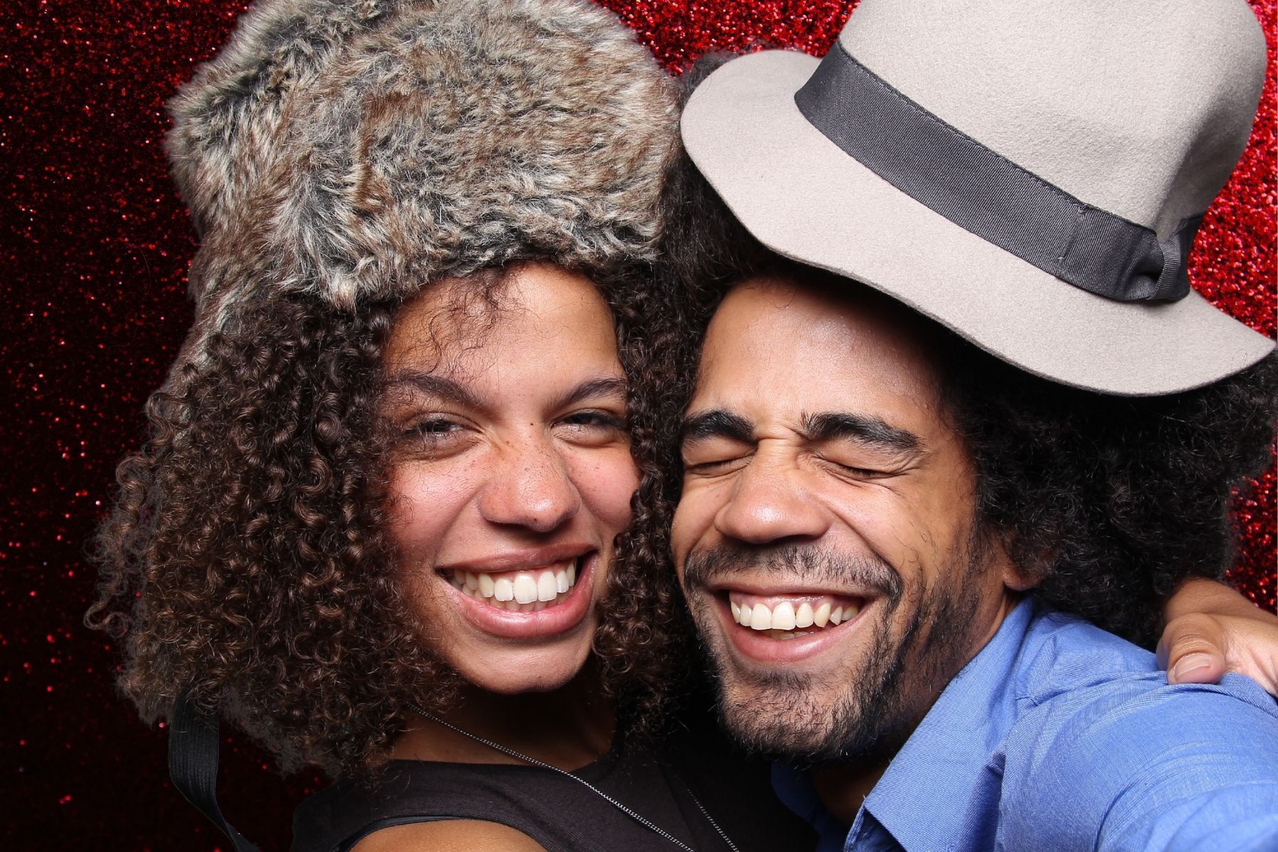 A man and a woman wearing hats are posing for a picture