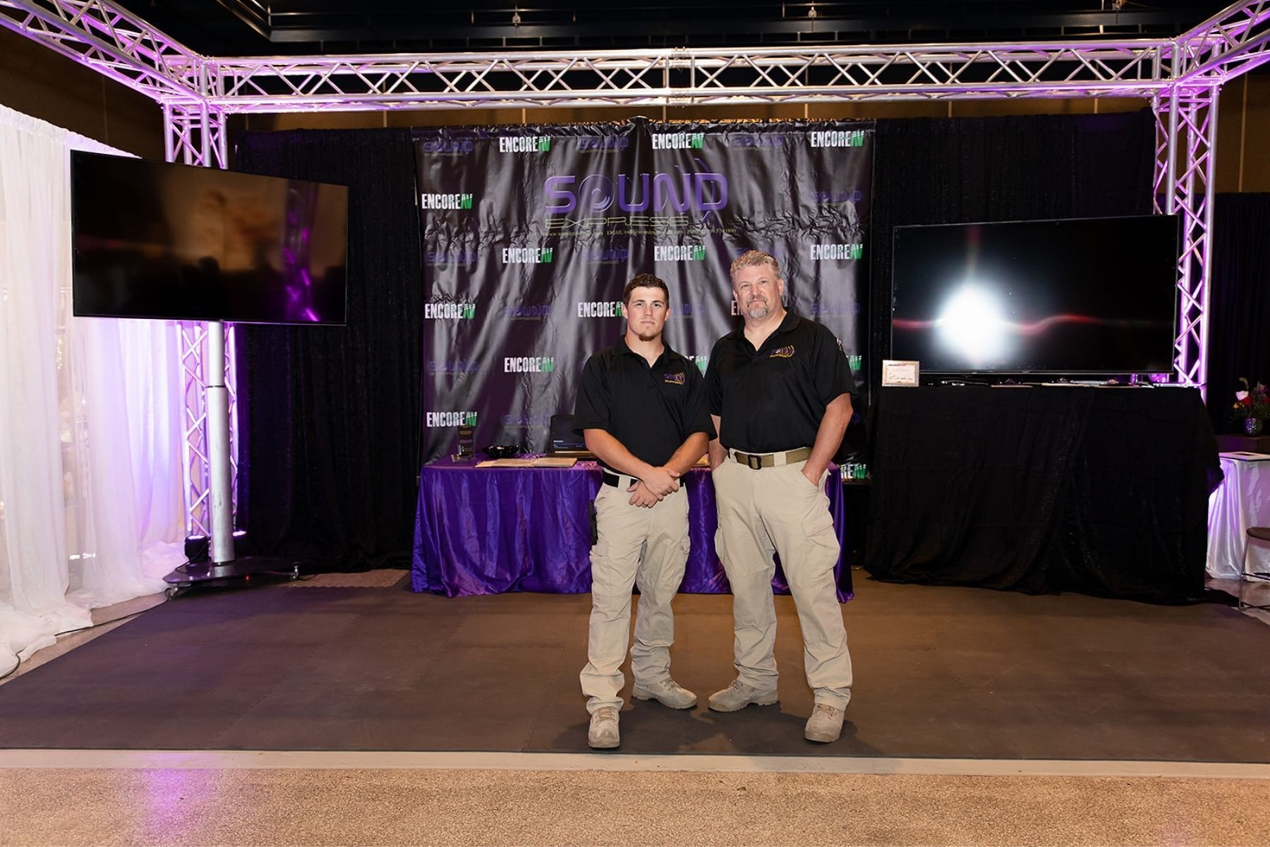 Two men are standing next to each other in a room.