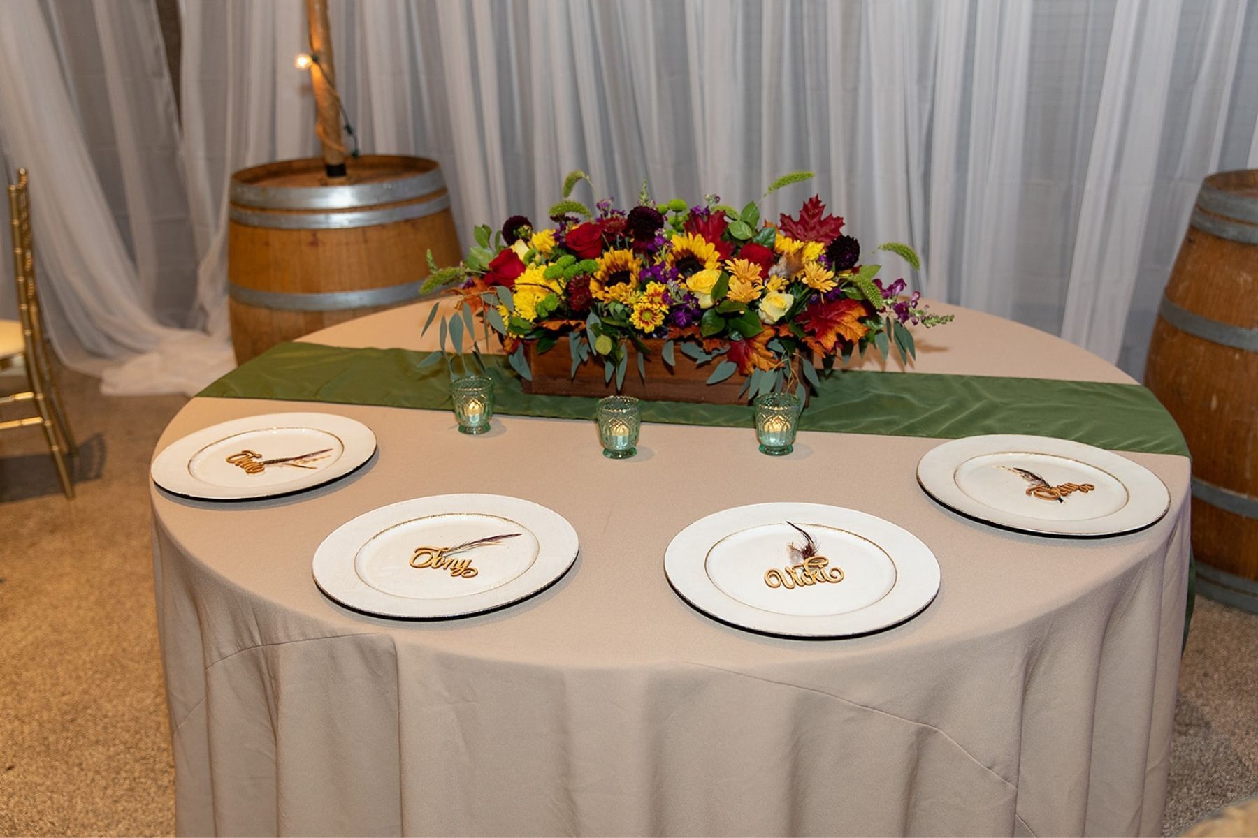 A table with plates and a vase of flowers on it.