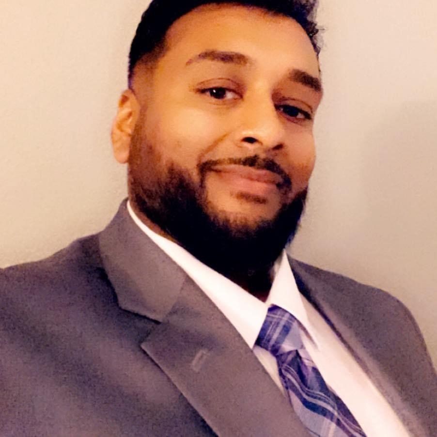 A man with a beard is wearing a suit and tie.