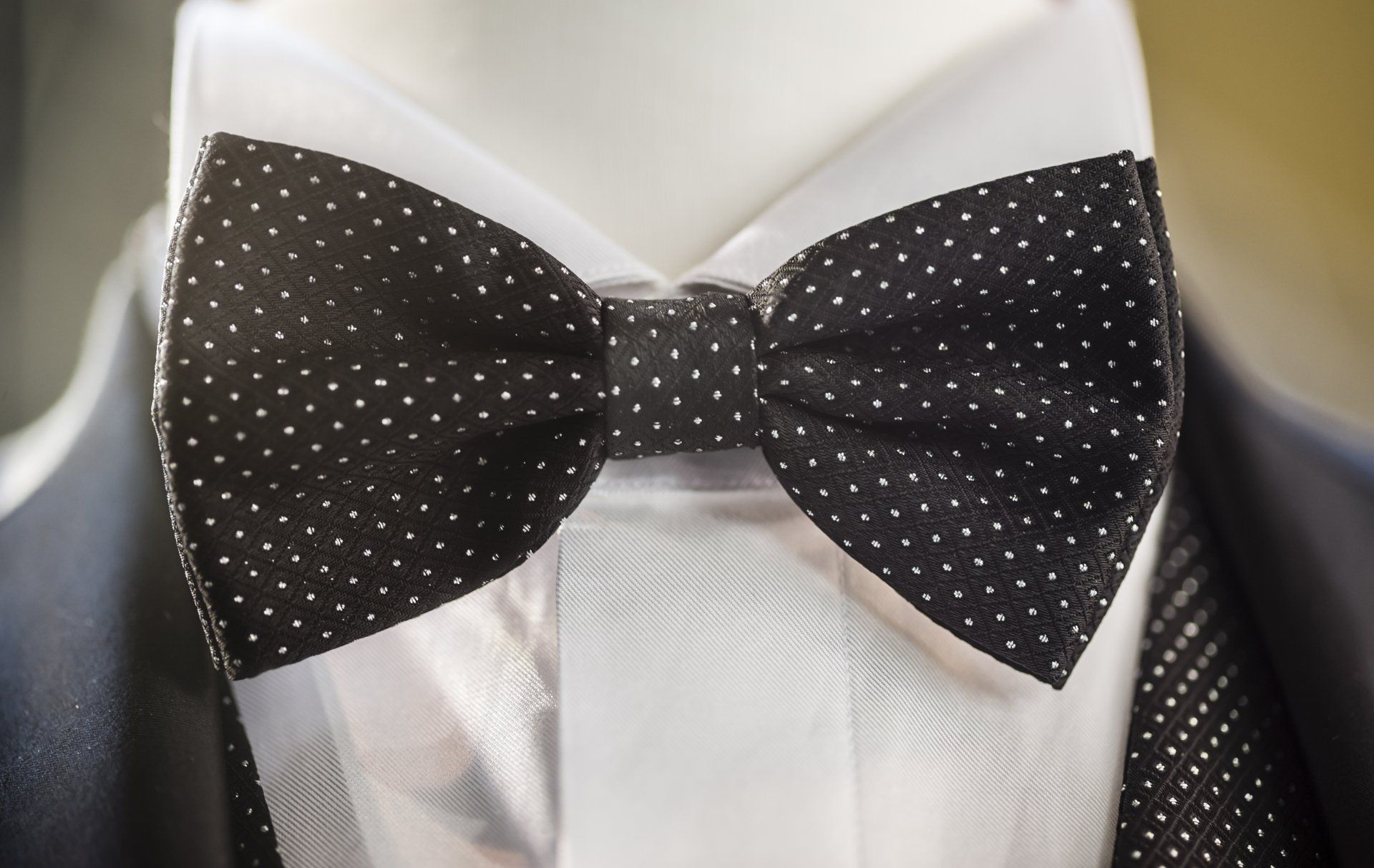 A man wearing a black and white polka dot bow tie