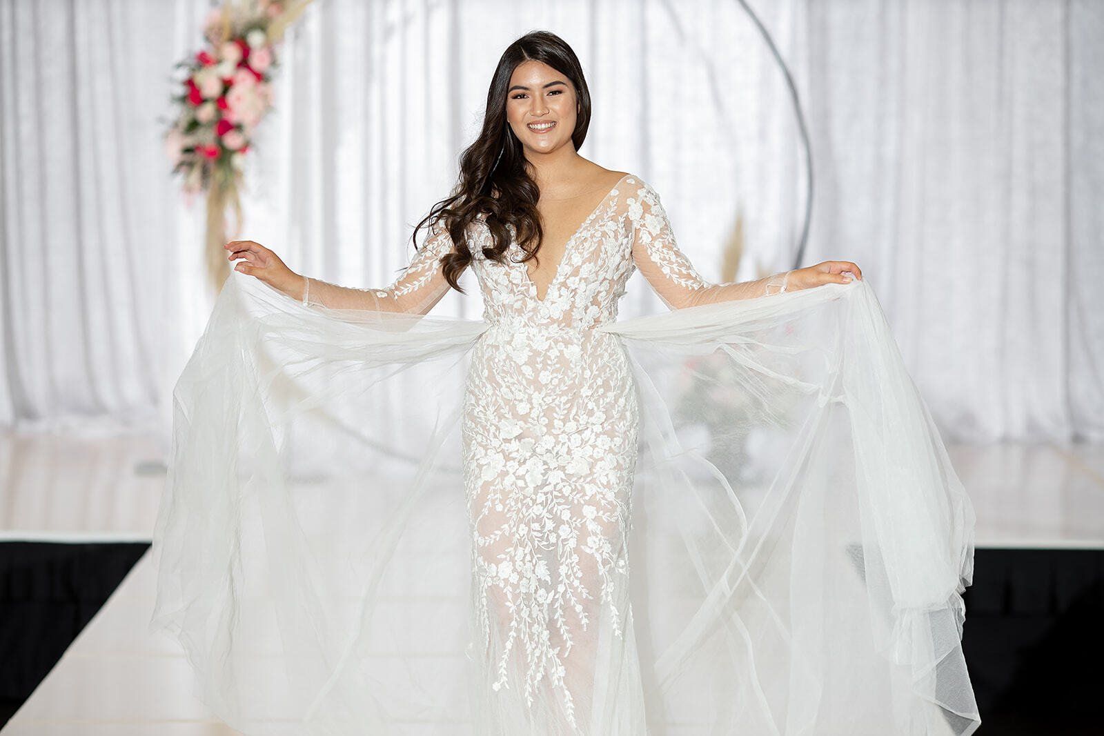 A woman in a wedding dress is walking down a runway.
