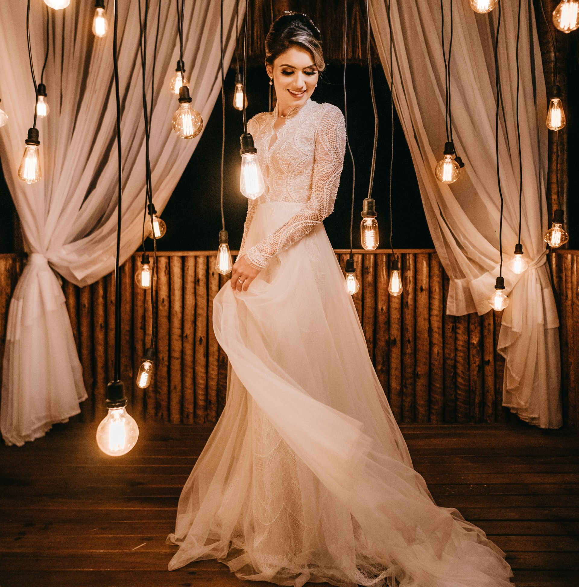 A woman in a wedding dress is standing in front of a bunch of lights