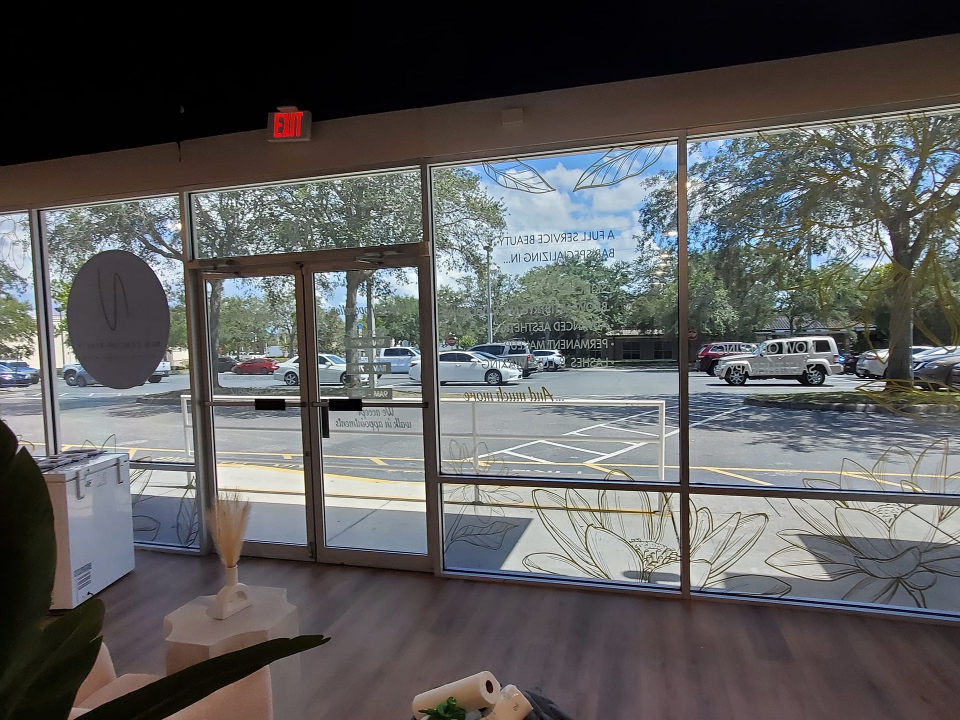 A room with a lot of windows and a parking lot in the background.
