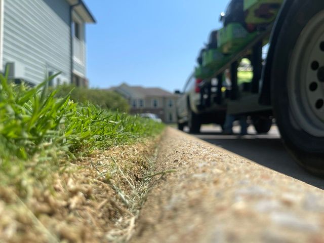 A car is parked on the side of the road next to a house.