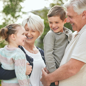 Smiling family hugging outdoors in soft daylight