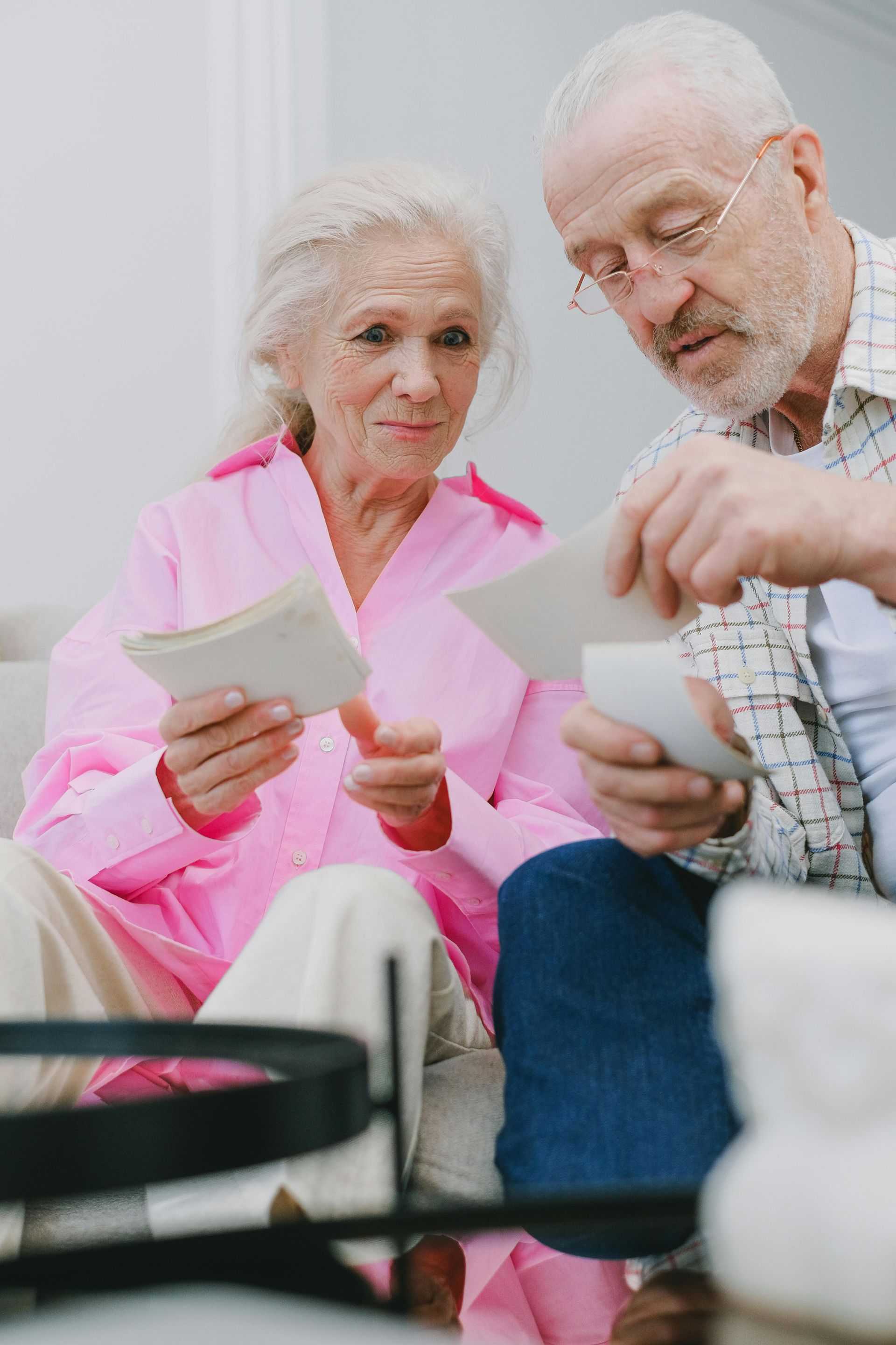 Older couple sitting together and sorting through papers, with a binder in the foreground