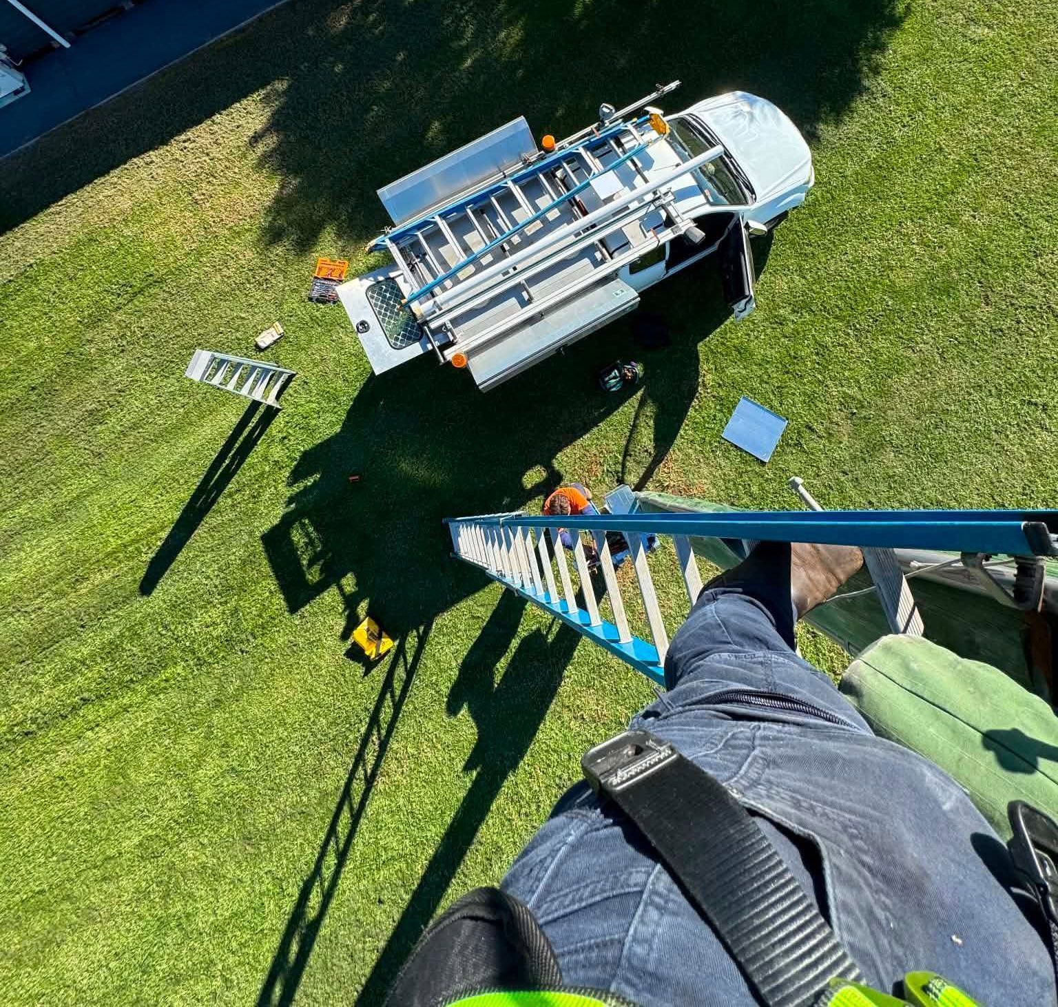 An Aerial View Of An Electrician on a ladder with Truck parked below — DMP Electrical Contractors In Dungog, NSW
