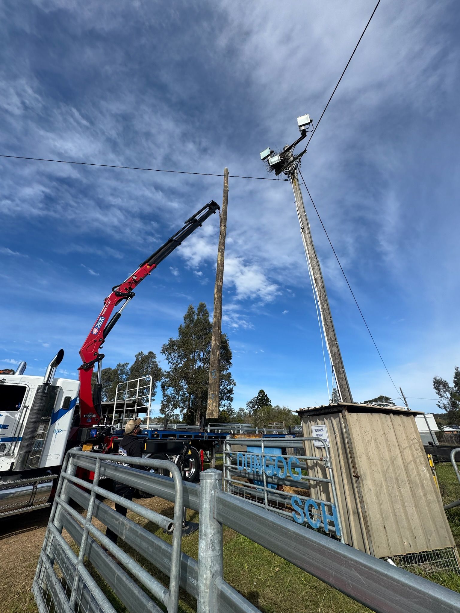 A Crane Lifts a Wooden Pole Near a Utility Pole with Equipment — DMP Electrical Contractors In Mandalong, NSW