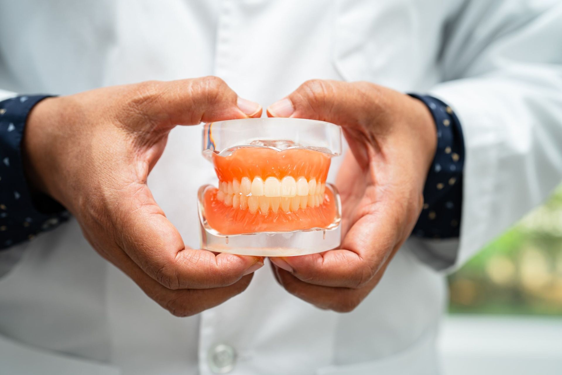 A Dentist is Holding a Model of Teeth in His Hands — Parap Family Dental in Parap, NT