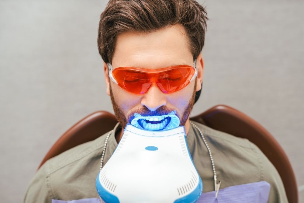 A Man is Getting His Teeth Whitened in a Dental Office — Parap Family Dental in Parap, NT