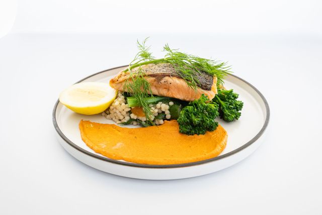 Pan-seared salmon dish on plate with vegetables and a lemon wedge — Jack West Photography In Kawungan, QLD