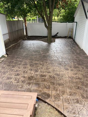 A group of men are working on a concrete floor in a yard.
