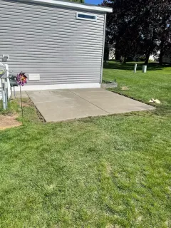 There is a concrete patio in front of a mobile home.