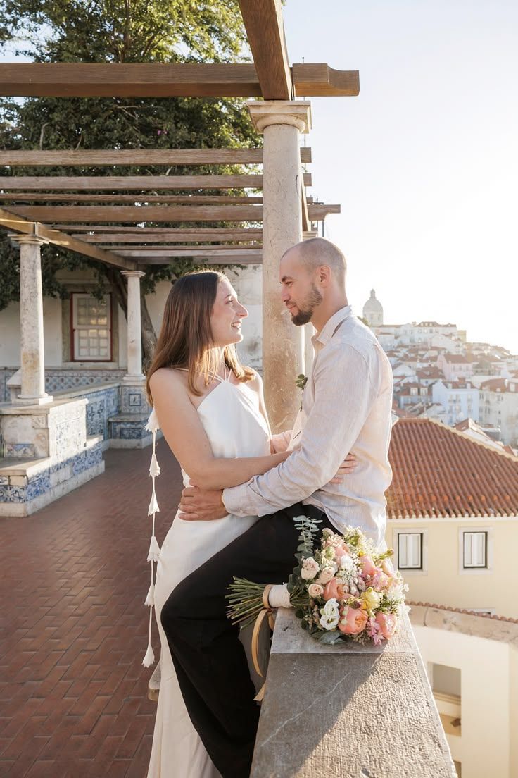 Couple embracing on a tiled terrace overlooking the rooftops of Sintra, Portugal.