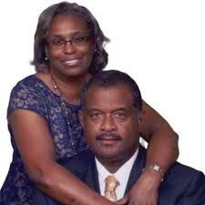 Portrait of a smiling couple in formal attire against a white background