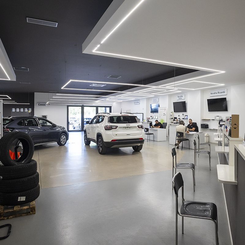 Un'auto è parcheggiata in uno showroom accanto a una pila di pneumatici.