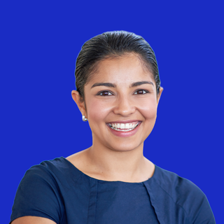 Smiling person in a navy top against a bright blue background