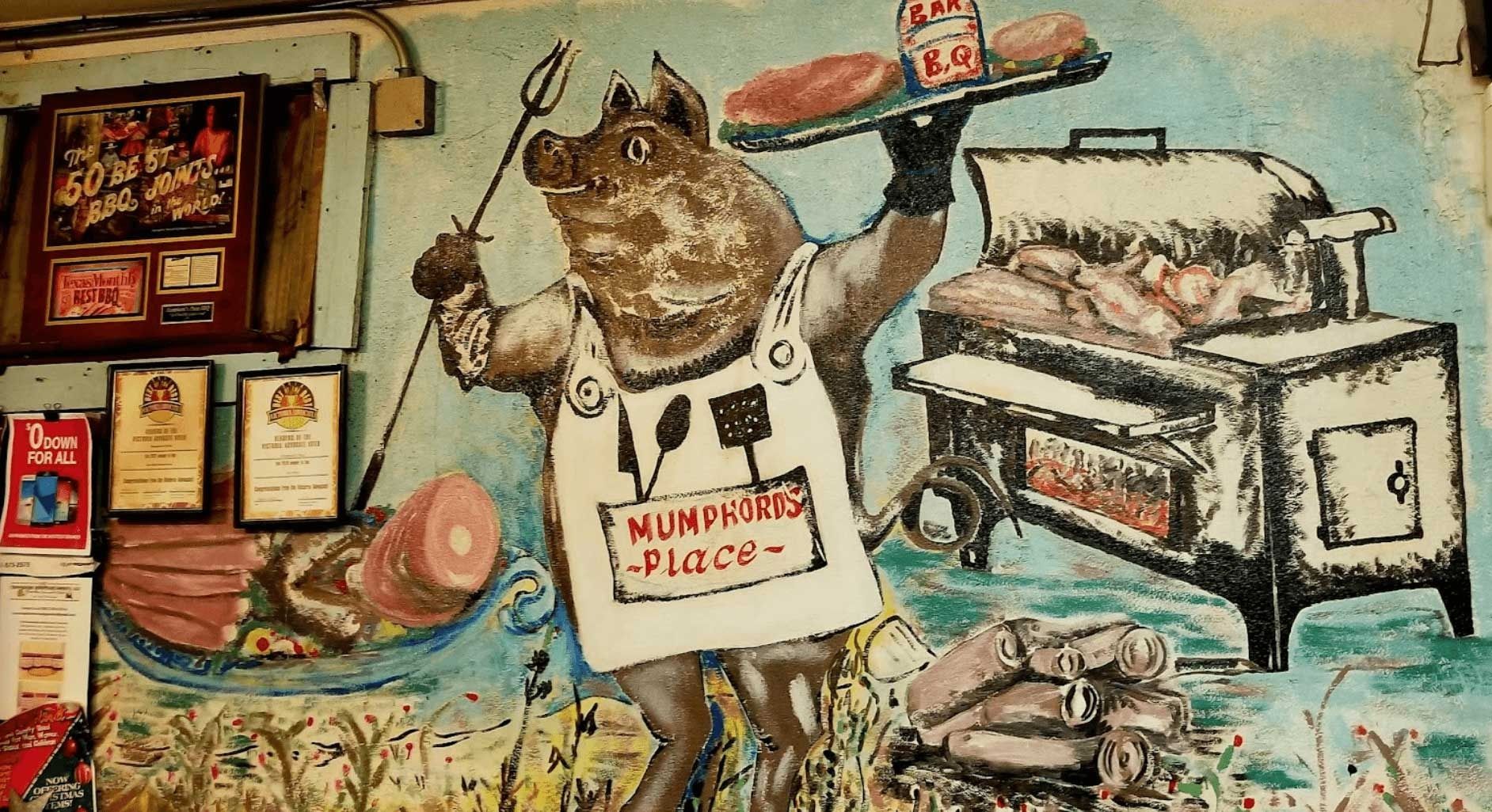Mural of a cat beside a bakery oven, with bread and a tray, in warm earthy colors
