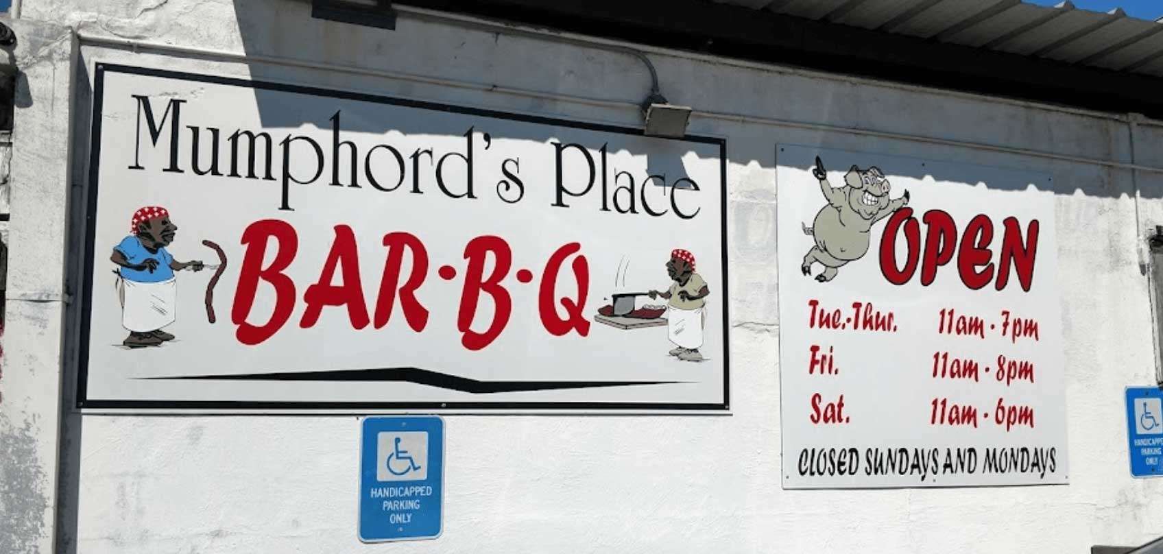 Mumford’s Place Bar-B-Q sign with hours and “OPEN” notice on a wall