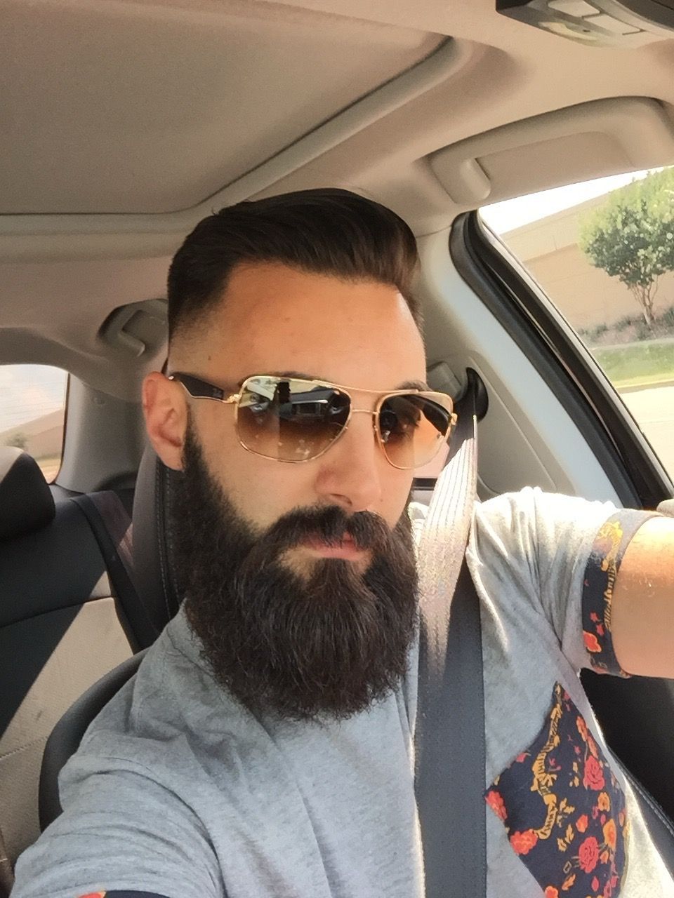 A man with sunglasses is sitting in a car