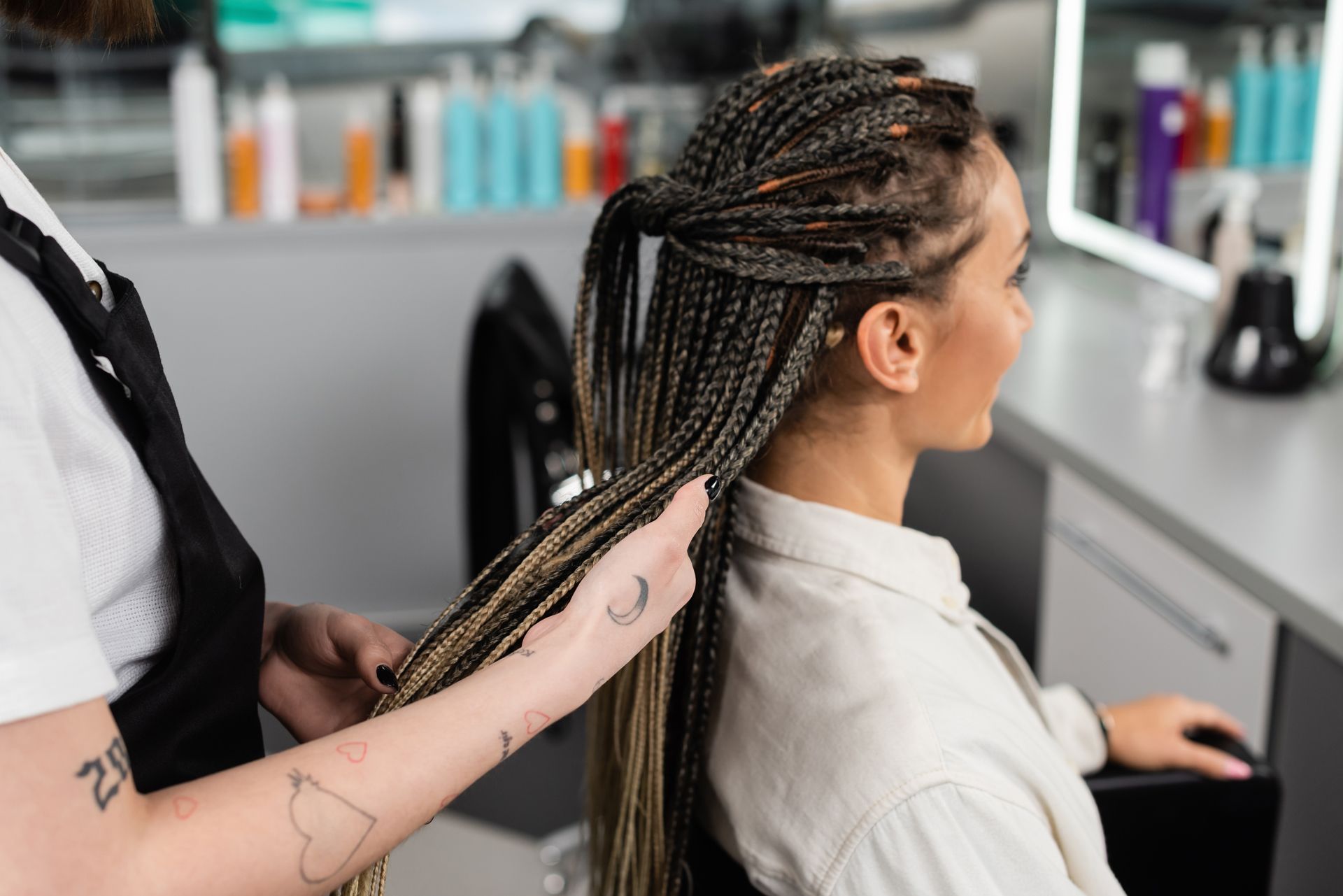 A Woman is Getting Her Hair Braided by a Hairdresser in a Salon