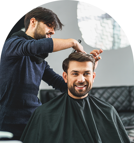 A Man is Getting His Hair Cut by a Barber in a Salon
