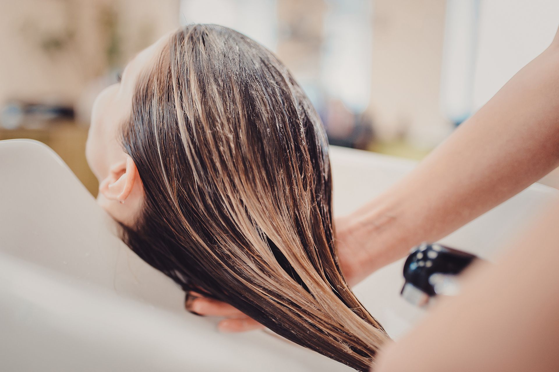 A Woman is Getting Her Hair Washed in a Sink at a Salon