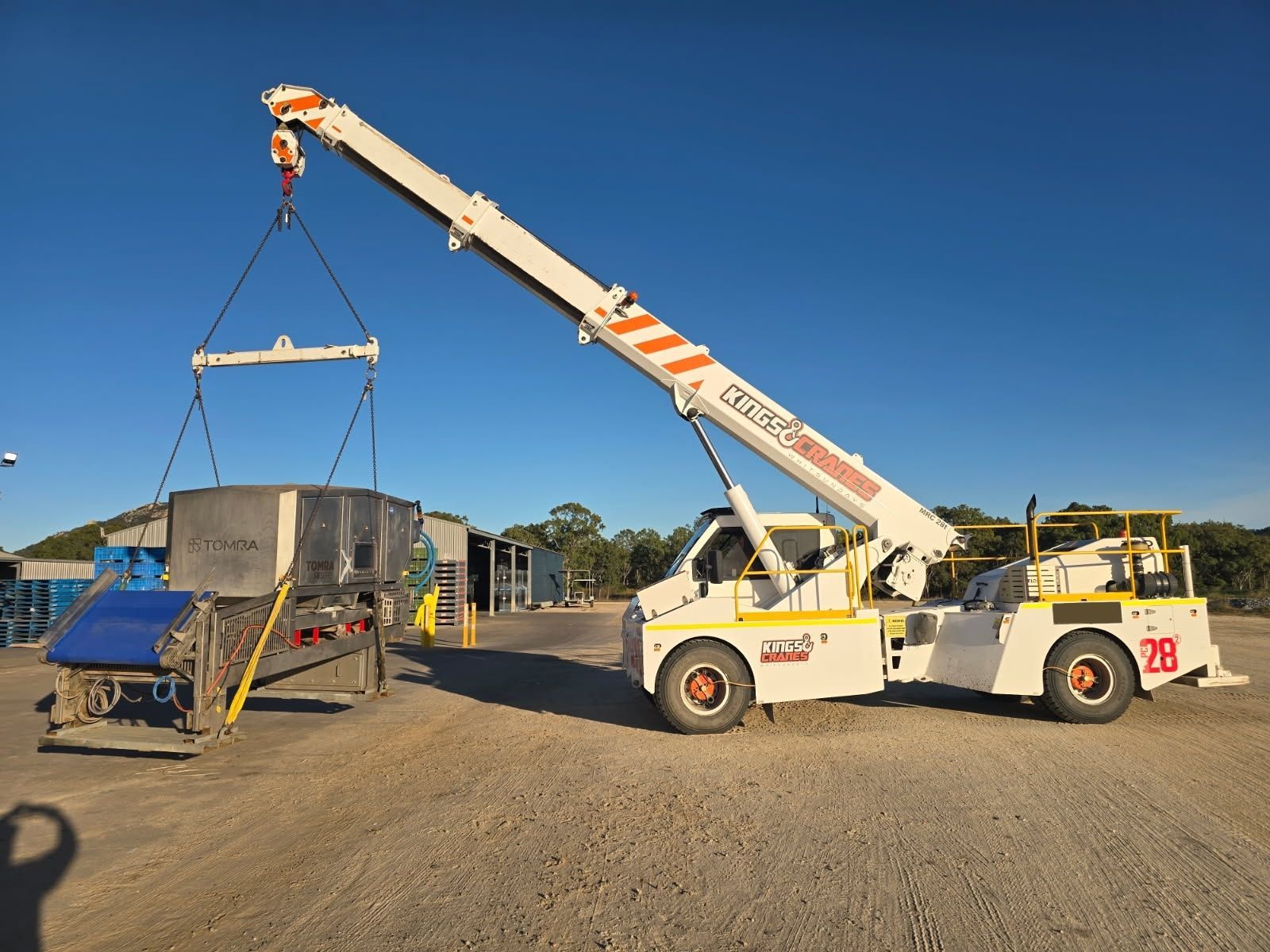 Tow truck lifting a white boat on a trailer in a sunny outdoor lot — Kings Cranes in Bowen, QLD
