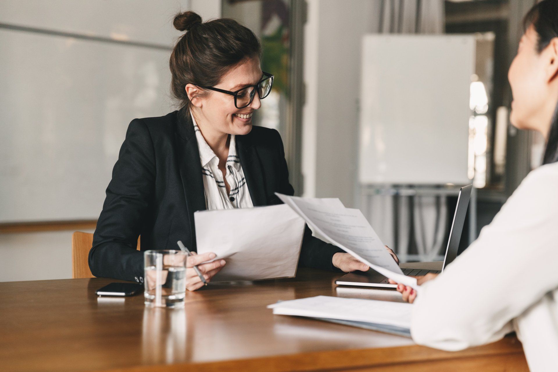 Two women are sitting at a table having a job interview.