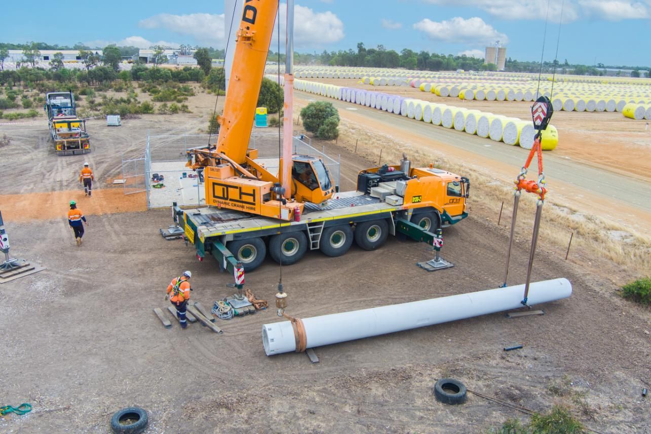 An Aerial View Of A Crane Lifting A Large Pipe On A Construction Site — Dynamic Crane Hire In Emerald, QLD