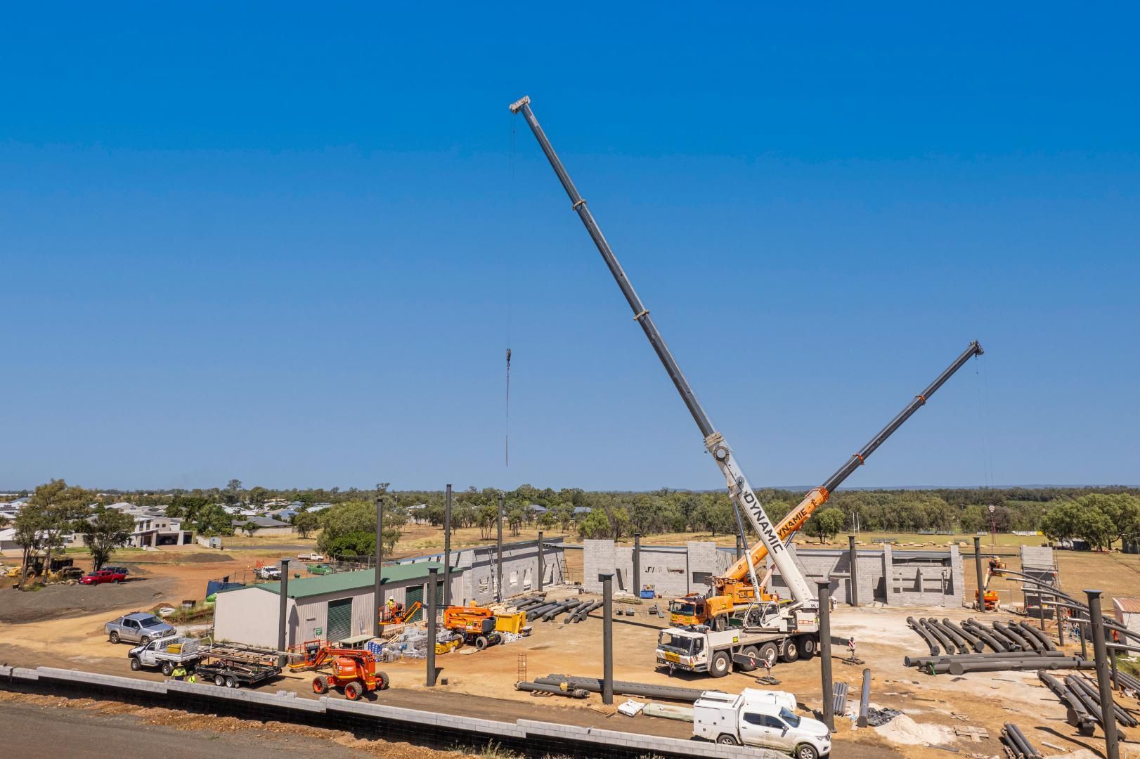 A Large Crane Is Being Used To Build A Building On A Construction Site — Dynamic Crane Hire In Biloela, QLD