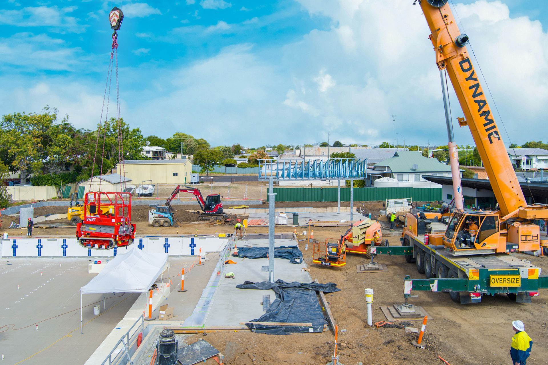 Construction site with cranes lifting equipment and workers — Dynamic Crane Hire In Emerald, QLD